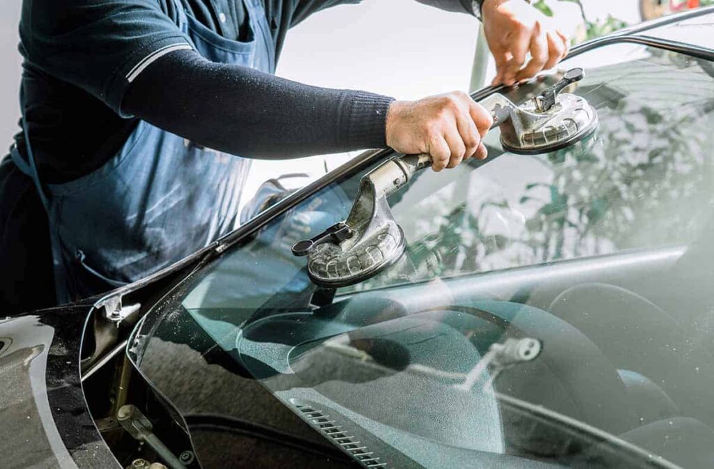 Front view of a white car with a severely shattered driver-side windshield requiring professional auto glass replacement in Surrey.