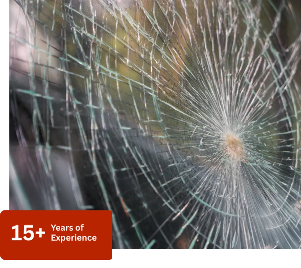 Close-up of a severely shattered windshield with a large spiderweb crack, showcasing the need for emergency auto glass replacement in Surrey.