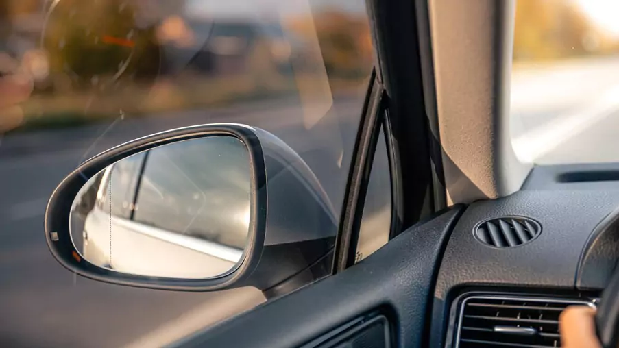 Close up of a car side mirror and window during a drive in Surrey, highlighting clear visibility and safe glass.
